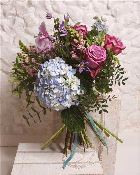Bouquet of flowers with hydrangeas and roses on a textured white background