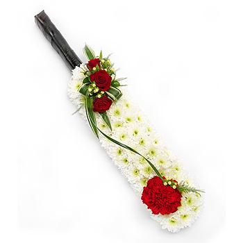 Floral arrangement on acricket bat against a white background