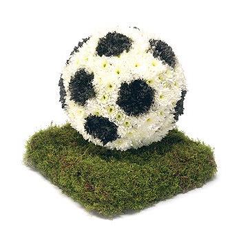 Floral arrangement shaped like a soccer ball on a bed of green moss.