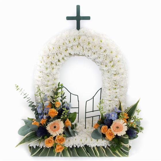 White floral wreath with a cross and decorative elements on a white background