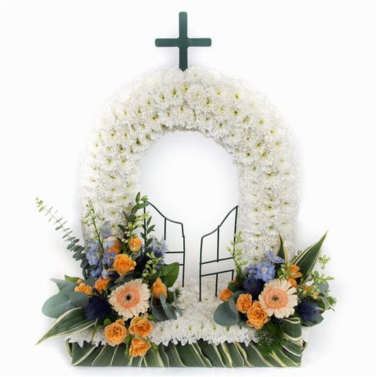 White floral wreath with a cross and decorative elements on a white background