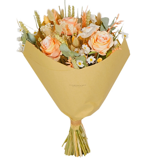Bouquet of flowers wrapped in gold paper on a white background