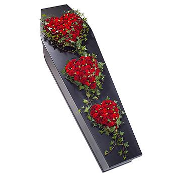 Coffin with red floral arrangements on a white background